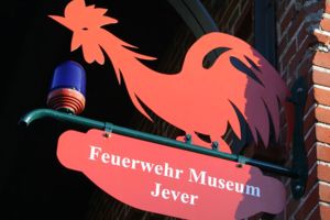 Feuerwehr Museum Jever Schild mit rotem Hahn und Blaulicht